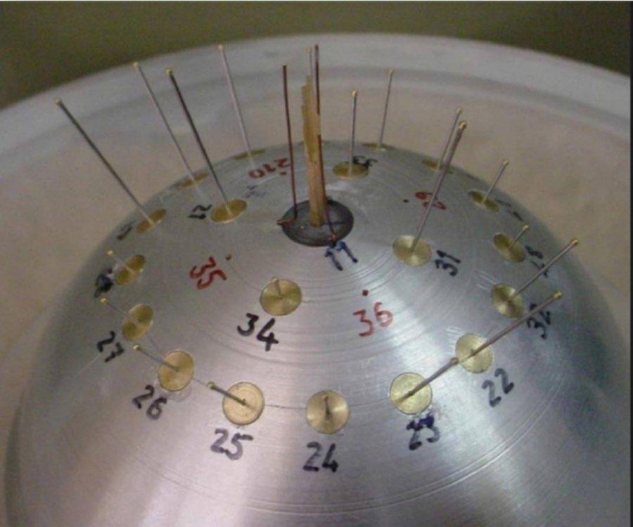 شکل ۴.۳. تصویر ماهواره‌ای گوگل ارث از ۲۰۰۴ از محل پارچین که ایران در آن تحت طرح آماد، آزمون انفجار شدید برای سلاح هسته‌ای را انجام می‌داد. این سایت به‌طور گسترده توسط ایران پاک‌سازی شده است. آرشیو هسته‌ای اطلاعات قابل‌توجهی درباره این محل دارد، به‌ویژه دو تأسیسات اصلی که دو محفظه انفجار شدید را در خود جای داده‌اند و در اسناد با نام‌های «تالهغان ۱» و «تالهغان ۲» آمده‌اند. «تالهغان ۱» بارها در فضای عمومی مطرح شده است. «تالهغان ۲» در ساختمانی مجاور قرار دارد و یک محفظه آزمون انفجار شدید کوچک‌تر با سامانه پرتو ایکسِ فلاش است. ساختمان «تالهغان ۲» تا زمان نگارش این کتاب توسط آژانس بین‌المللی انرژی اتمی بازدید نشده بود. سرنوشت این محفظه‌ها و تجهیزات مرتبط هنوز نامعلوم است.