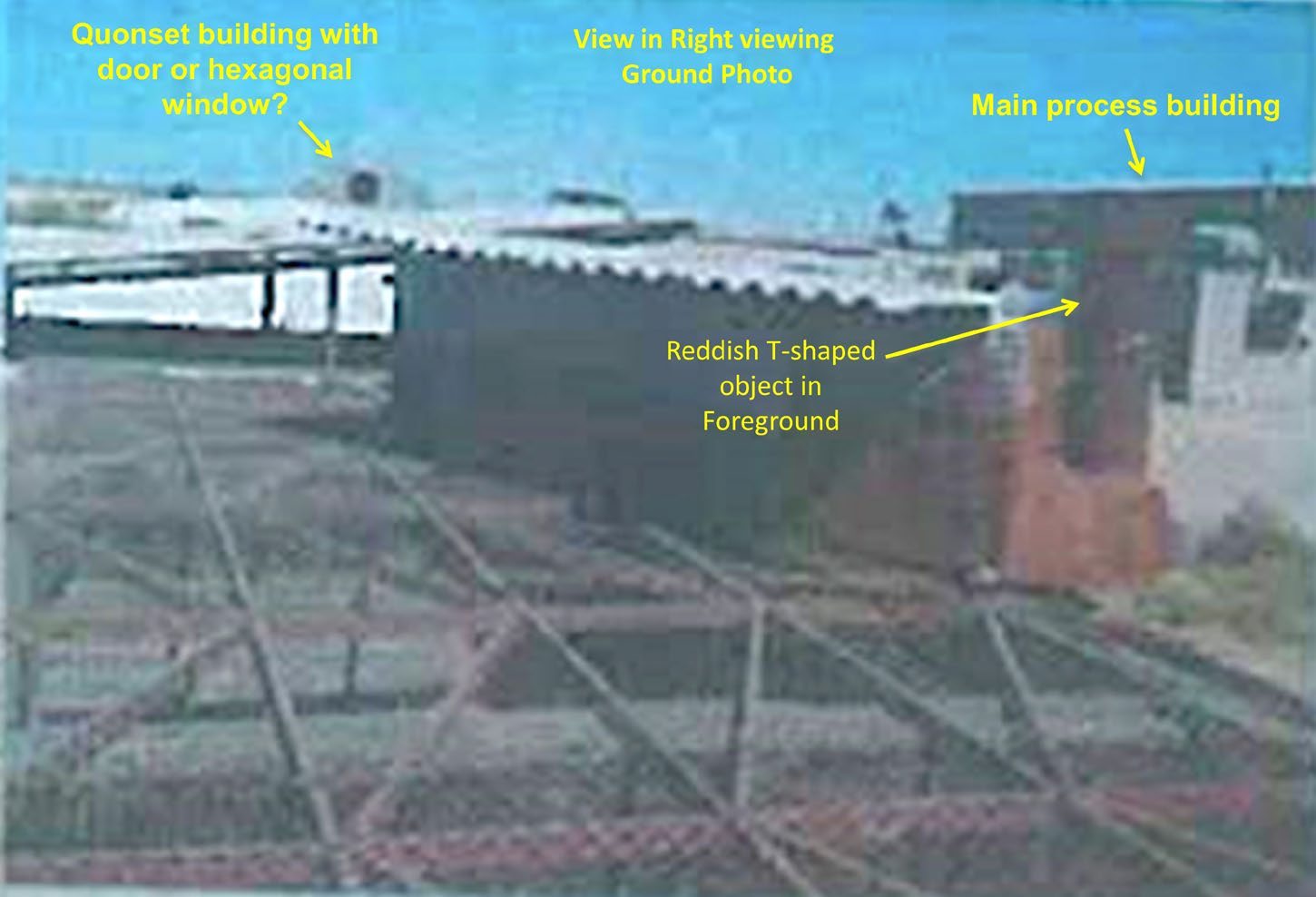 شکل ۸.۱۰. تصویر دیگری از یکی از شکل‌های سندِ موردبحث در متن، درباره دفع پسماند. همان جسم T‌شکل قهوه‌ای مایل‌به‌قرمزِ شکل ۸.۸ دیده می‌شود، اما از زاویه‌ای متفاوت، همراه با بخش‌های دیگری از سایت. در پس‌زمینه یک ساختمان کانوست دیده می‌شود که هنوز هم پابرجاست. سقف ساختمان اصلی سایت (ساختمان اصلی فرایند) در پس‌زمینه و در سمت راست تصویر است.