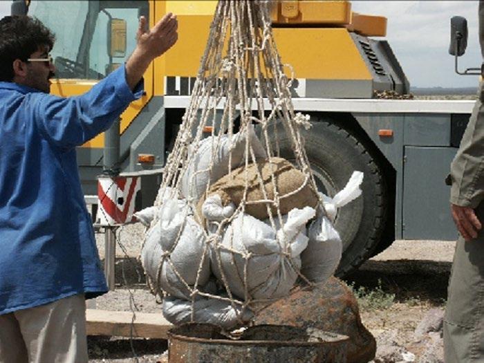 شکل ۹.۲۲. گزارش انتخاب محل از آرشیو هسته‌ای توسط «گروه ۸»، با تاریخ اوت ۲۰۰۲. ترجمه صفحه عنوان در سمت راست. همان‌طور که پیش‌تر گفته شد، مُهر آبی‌رنگ در بسیاری از اسناد آرشیو معمول است؛ در آن شماره سند و تعداد صفحات آن درج می‌شود. در اینجا نوشته روی مهر ناخواناست.